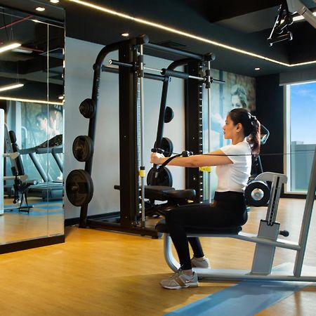 Royal Continental Suites Business Bay Dubai Exterior photo A woman using a seated row machine