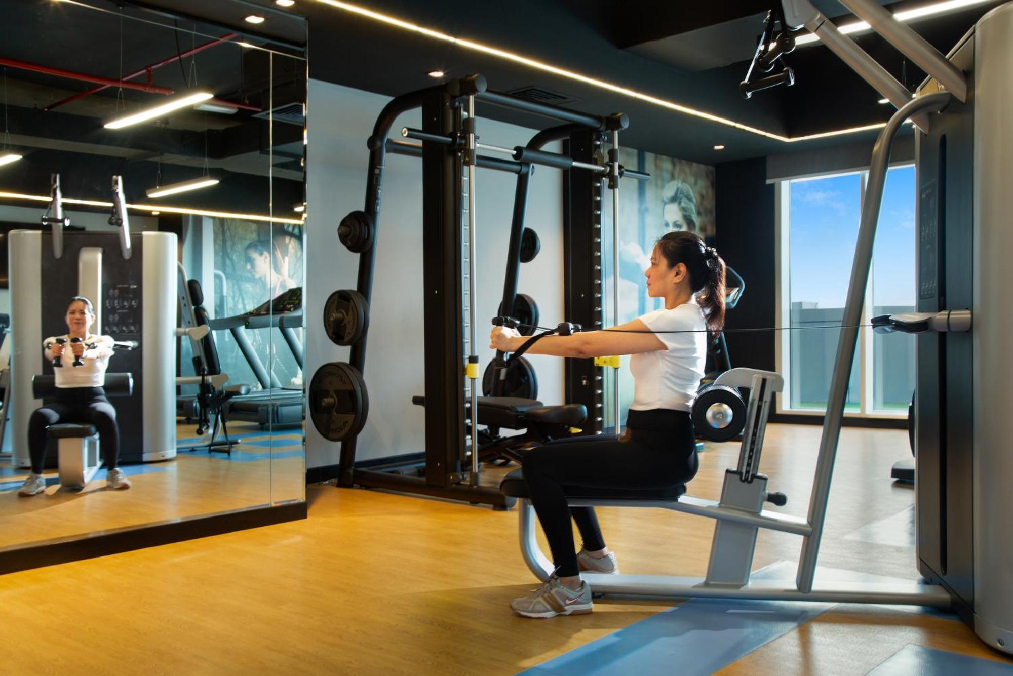 Royal Continental Suites Business Bay Dubai Exterior photo A woman using a seated row machine